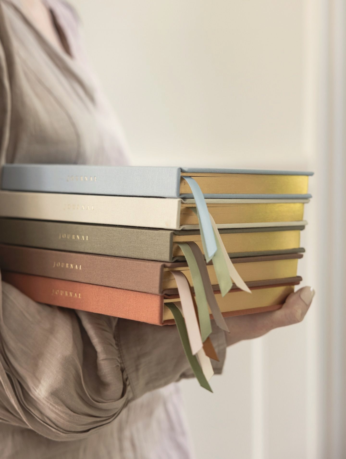 Someone carrying a stack of cloth notebooks