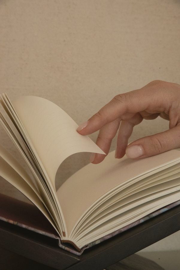 A hand turning through a finished notebook